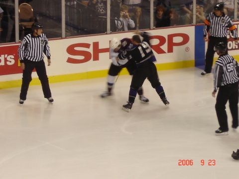 1993 Ford Bronco - Two hockey players are engaged in a fight on the ice while referees observe the action.