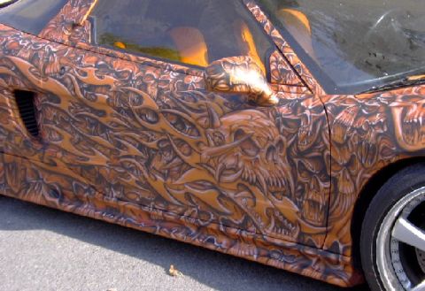 1978 Ford Mustang II - A car's side panel is covered in a detailed custom paint job skulls and flames.