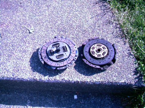 1987 Ford Bronco II - Two clutch assemblies are shown on a concrete surface next to grass.