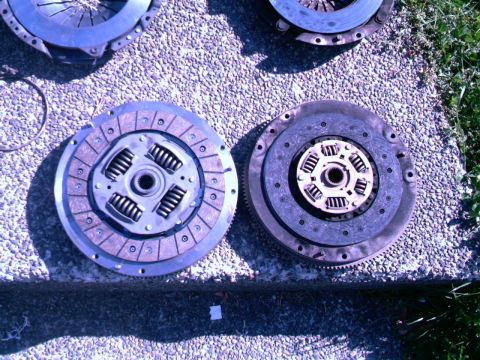 1987 Ford Bronco II - Two automotive clutch assemblies are laid out on a textured surface.