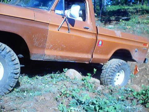 1976 Ford F-100 - This pickup truck appears to be from the 1970s, with a boxy body style and off-road tires.