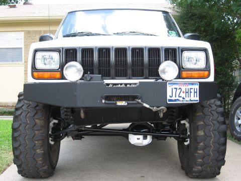 1986 Ford Bronco - This modified Jeep Cherokee XJ features an aftermarket bumper and large tires, suggesting off-road use.