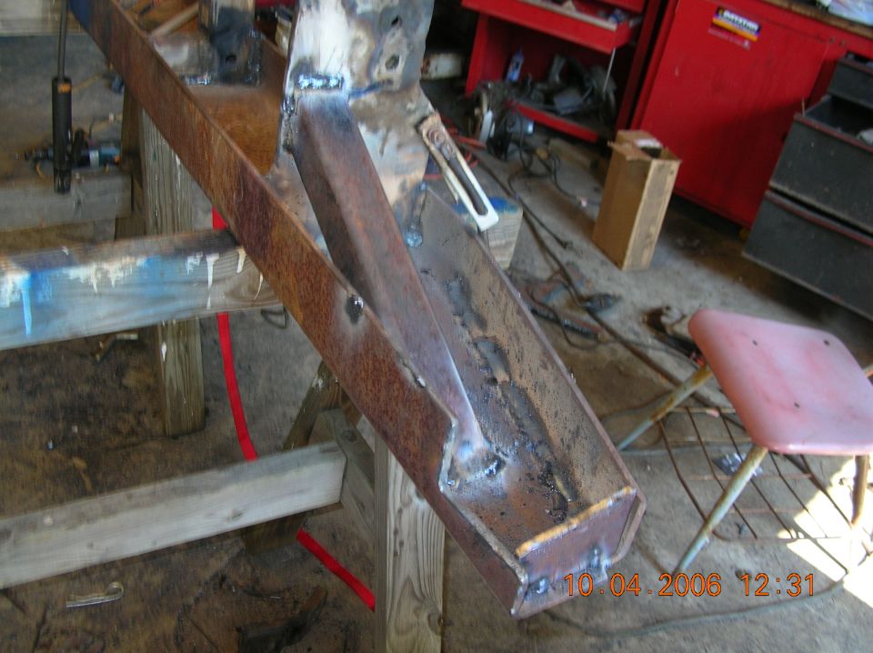 rusted metal frame section with visible welds, supported by wooden sawhorses
