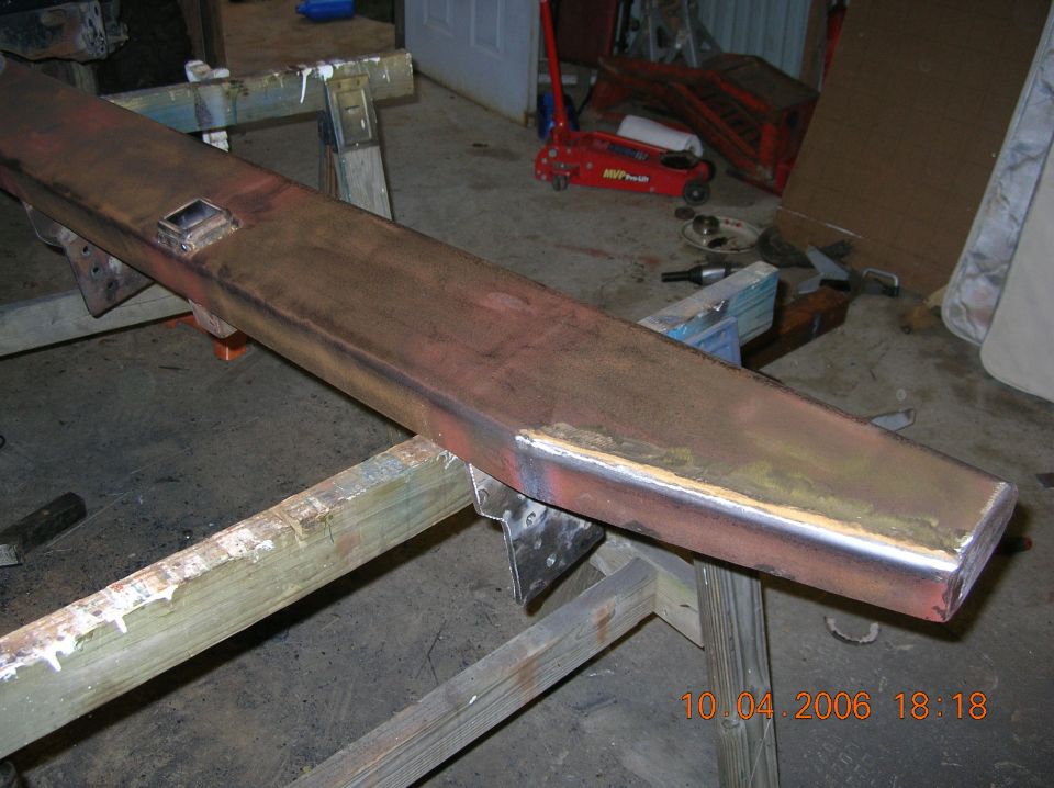 Custom steel bumper section on sawhorses, showing welds and a square cutout