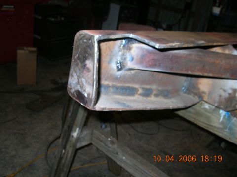 1991 Ford F-150 - A close-up shot shows a rusty, welded metal component resting on sawhorses in a workshop.