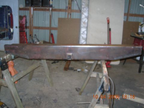1991 Ford F-150 - A weathered rear bumper is displayed on sawhorses in a workshop setting.