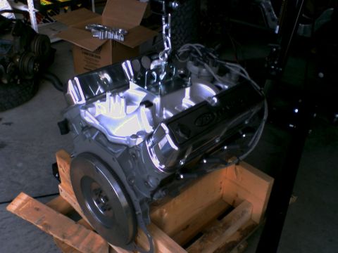 1983 Ford Bronco - Engine with chrome valve covers and intake manifold sits on a wooden pallet.
