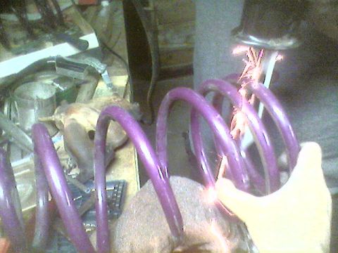 1993 Ford Taurus - A person is working on a purple coil spring with a tool that is creating sparks.