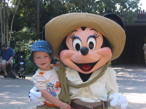 1995 Ford Bronco - A child smiles while posing with Minnie Mouse at an outdoor attraction.