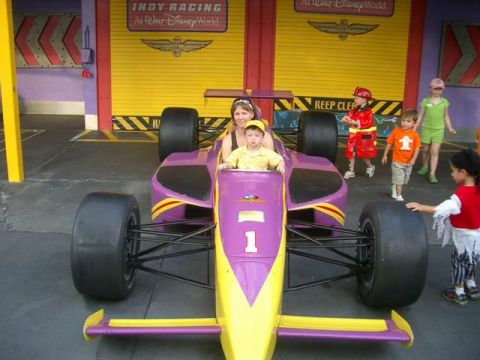 1995 Ford Bronco - A family poses in a stationary Indy-style race car attraction at Walt Disney World.