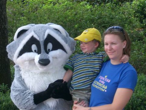 1995 Ford Bronco - A woman and child pose with a mascot raccoon in an outdoor setting.