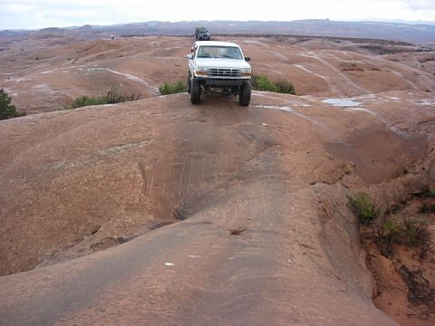 1993 Ford Bronco - A white 1992 Ford F-150 navigates a rocky off-road path, with another vehicle following in the distance.