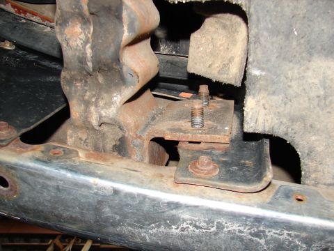1996 Ford Bronco - Close-up of a rusty tow hook bracket attached to a vehicle's frame, showing bolts and mounting hardware.
