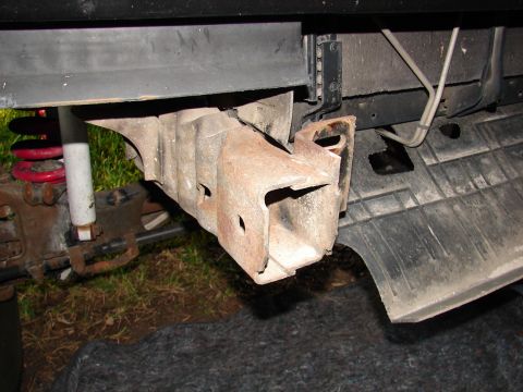 1996 Ford Bronco - Close-up view of a rusted tow hook bracket, part of the undercarriage of a vehicle.
