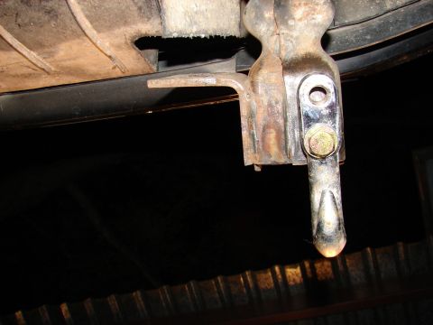 1996 Ford Bronco - A close-up view of a tow hook, showing its rusty metal construction and a chrome-plated tip.