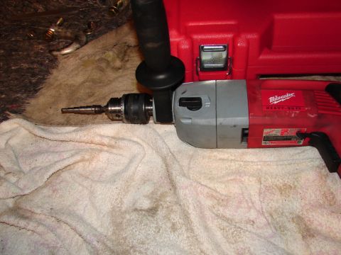 1996 Ford Bronco - A Milwaukee Heavy Duty drill with a step bit is shown on a white towel, next to a red toolbox.