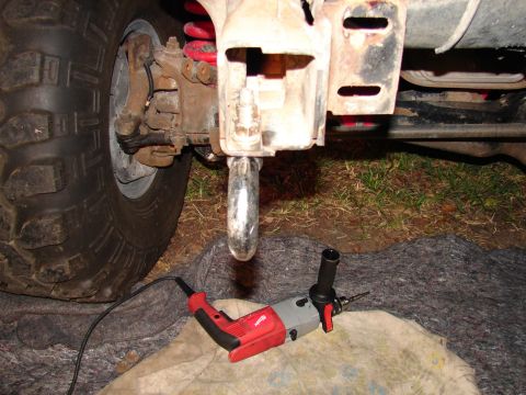 1996 Ford Bronco - A drill sits on a blanket near a vehicle's tow hook, suggesting a repair or modification is underway.