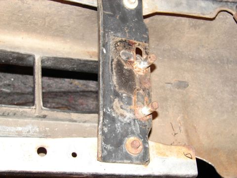 1996 Ford Bronco - Close-up view of a corroded tow hook mounting bracket on a vehicle's undercarriage.