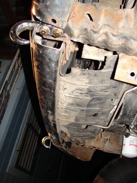 1996 Ford Bronco - Close-up of tow hooks and an oil filter mounted to the undercarriage of a vehicle.