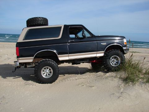 1996 Ford Bronco - This lifted 1996 Ford Bronco is shown on a sandy beach with the ocean in the background.