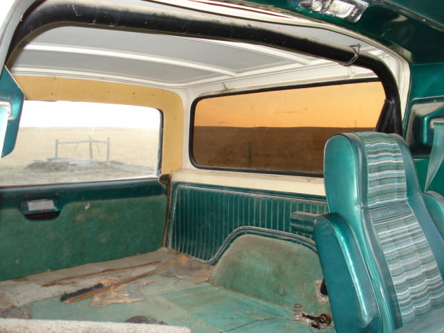 Green interior of a 1978 Ford Bronco with striped seats and worn carpet