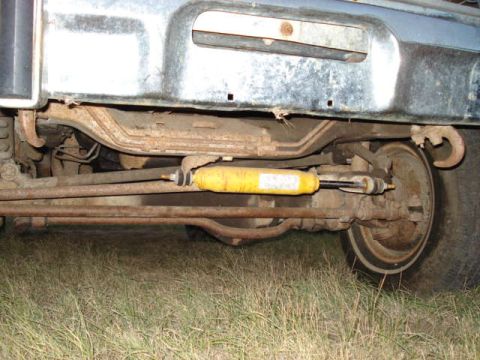 1979 Ford Bronco - A close-up view of the undercarriage reveals the vehicle's suspension system, including a prominent yellow shock absorber.