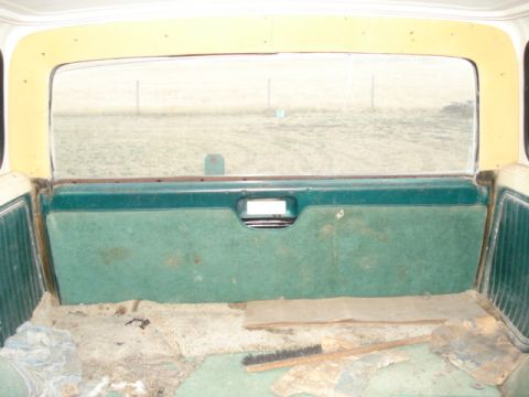 1979 Ford Bronco - The rear interior panel of a 1979 Ford Bronco, green carpet and a view through the rear window.