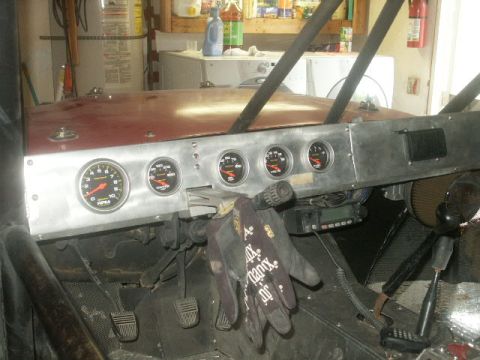 1992 Toyota Tacoma - The interior of a modified vehicle shows a custom dashboard with several gauges and a CB radio.