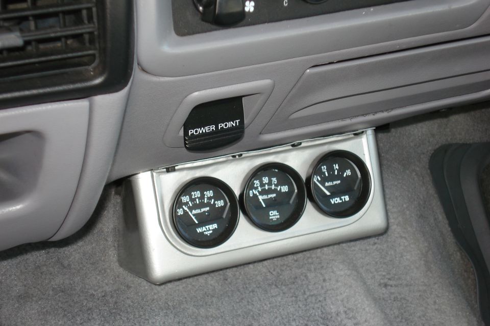 Dashboard with three gauges: water, oil, and volts. A black power point is visible
