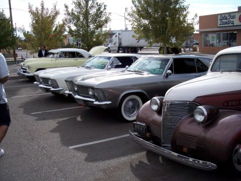 1972 Ford Ranchero - A line of vintage automobiles are parked in a lot, including a prominent brown and cream colored car in the foreground.