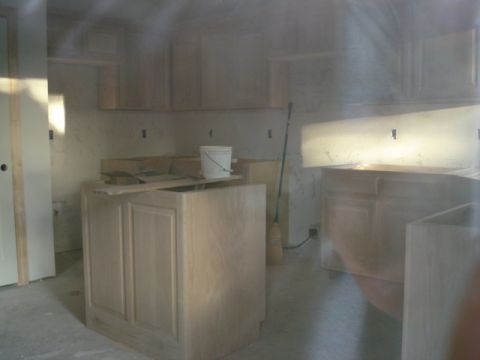 1994 Ford Bronco - Unfinished kitchen cabinets and island are visible in this construction scene. A bucket sits on the island countertop.