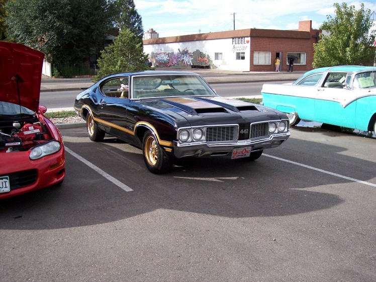 Black 1970 Oldsmobile 442 with gold stripes and gold wheels