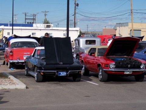 1972 Ford Ranchero - A black 1967 Chevrolet Corvette Stingray coupe is parked with its hood open at a car show.