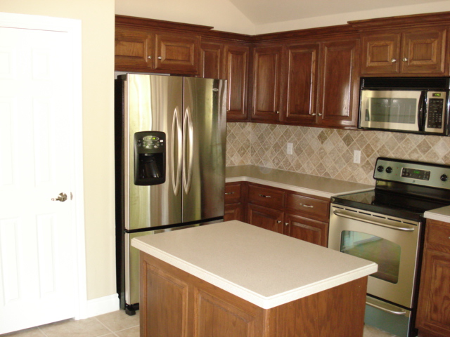 Kitchen with stainless steel refrigerator, wooden cabinets, and a stove
