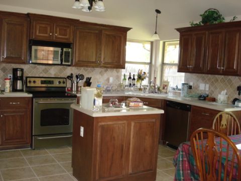 1994 Ford Bronco - A view of a kitchen wooden cabinets, a central island, and a dining table with a plaid tablecloth.