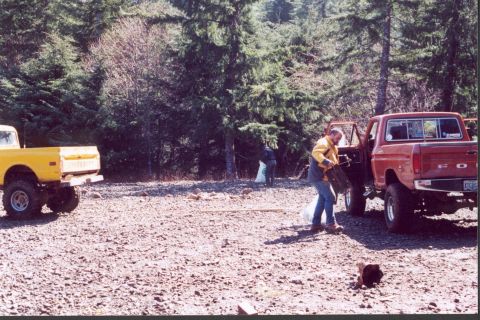 1976 Ford F-100 - Two pickup trucks are present at a cleanup site with people working.