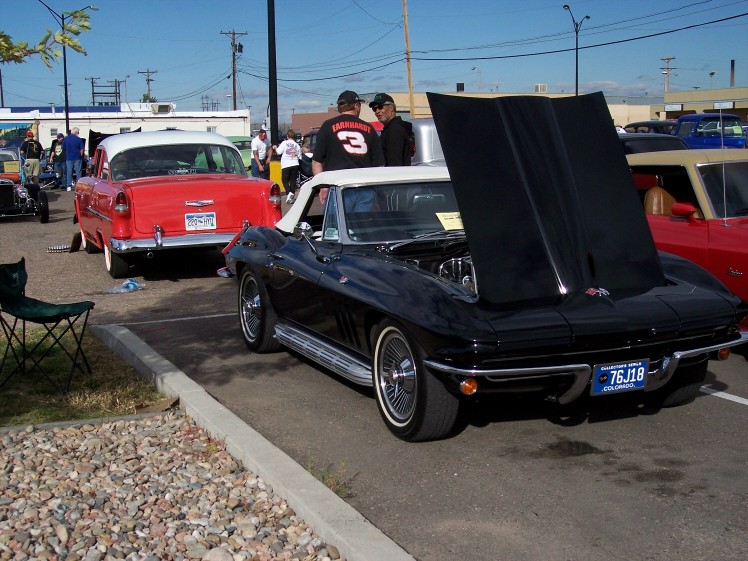 Black 1965 Corvette convertible with hood open, white interior, chrome trim
