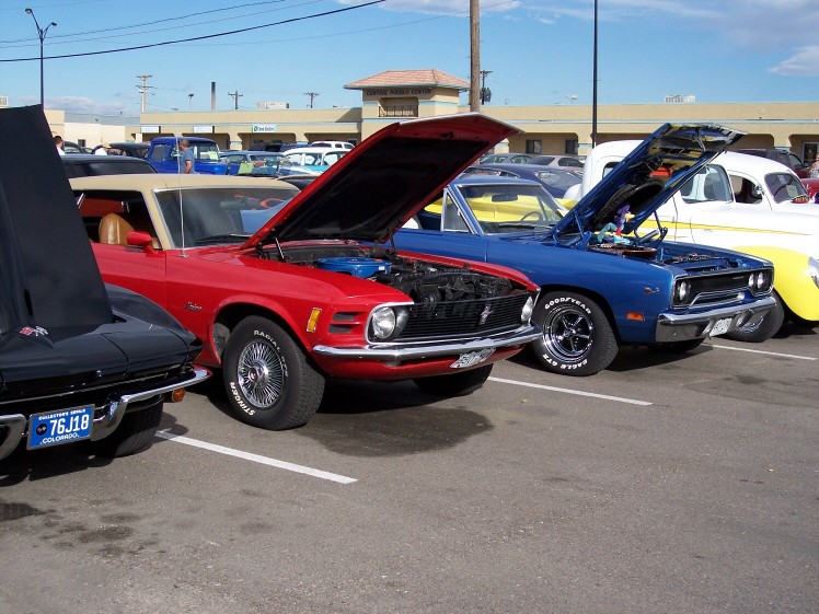 Red 1970 Ford Mustang convertible with hood open, parked next to a blue car