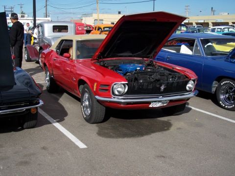 1972 Ford Ranchero - A red 1970 Ford Mustang convertible is displayed with its hood open at an outdoor car show.