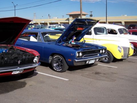 1972 Ford Ranchero - A blue 1970 muscle car is parked with its hood open at a car show, alongside other vehicles.