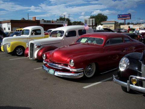 1972 Ford Ranchero - A row of classic cars at a car show, a red coupe in the foreground.