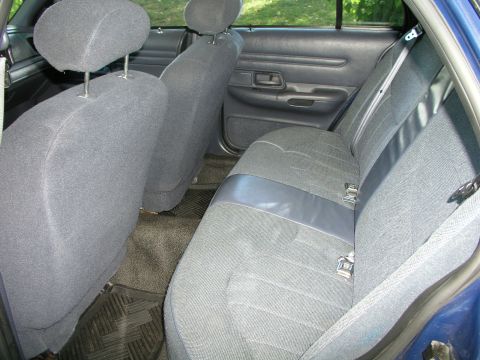 1999 Ford Crown Victoria - The interior of a blue sedan shows the rear bench seat and door panel.