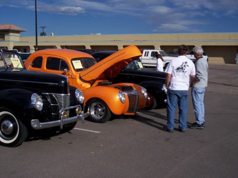 1972 Ford Ranchero - Several classic cars are on display at an outdoor event, with people admiring them.