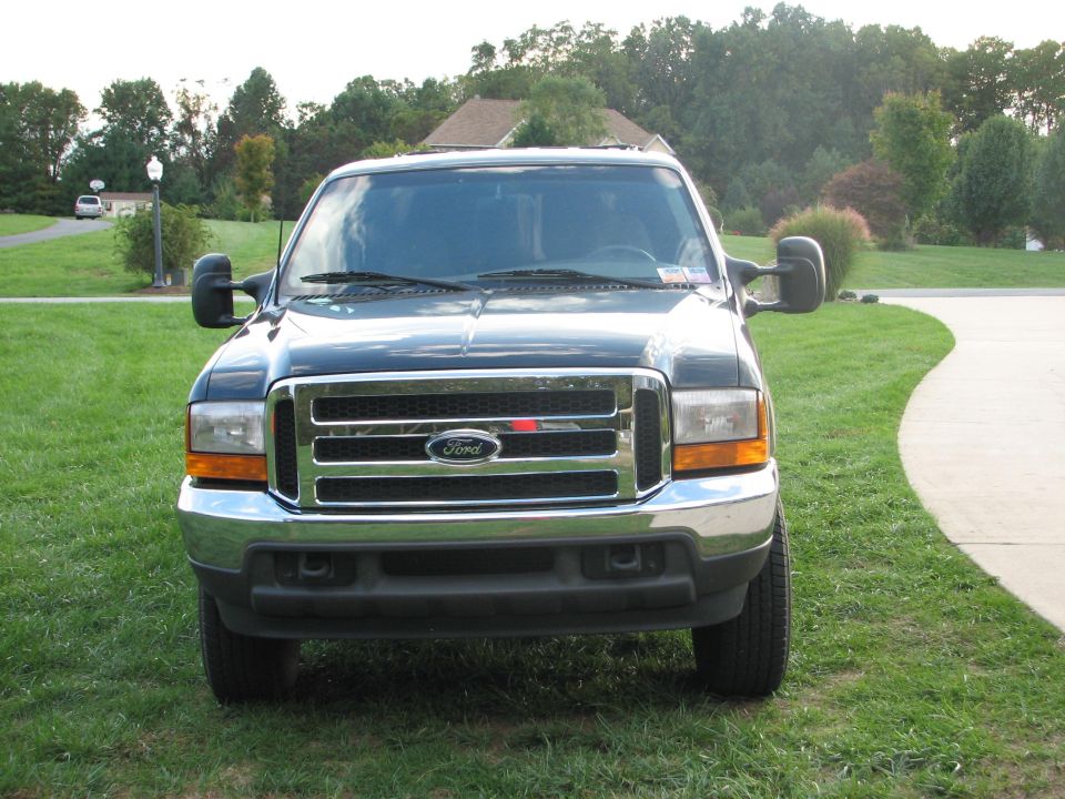 Front view of a dark green Ford Super Duty truck on a lawn