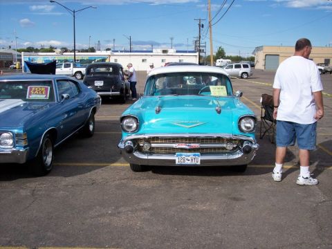 1972 Ford Ranchero - A turquoise 1957 Chevrolet Bel Air is displayed at a car show, with another car visible to the left.