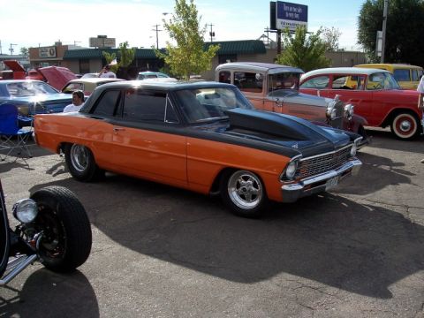 1972 Ford Ranchero - A modified coupe with a prominent hood scoop is displayed at an outdoor car event.
