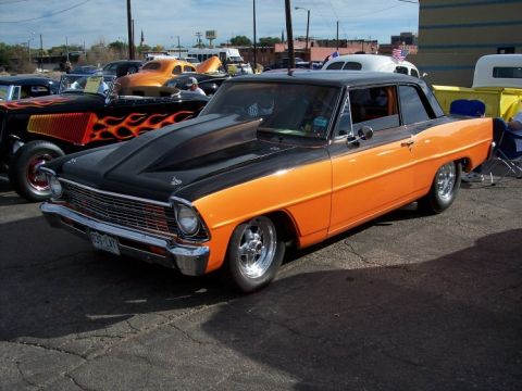 1972 Ford Ranchero - A customized coupe with a prominent hood scoop and two-tone paint sits at an outdoor car show.