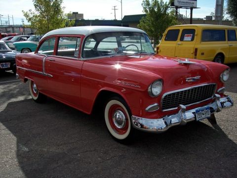 1972 Ford Ranchero - Red 1955 Chevrolet Bel Air with white roof and wide whitewall tires parked next to a yellow van.