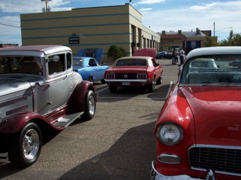 1972 Ford Ranchero - A collection of vintage automobiles are gathered in a parking lot under a partly cloudy sky.