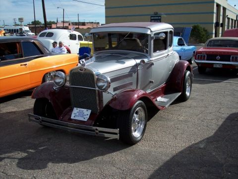 1972 Ford Ranchero - A two-tone 1930 Ford Model A coupe is parked at a car show with other vehicles.